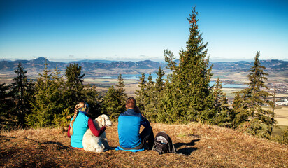 Hiking couple looking on beautiful landscape from top of the hill