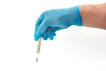 Man's hand in blue latex glove holding medical thermometer isolated on white background. Medical topic concept