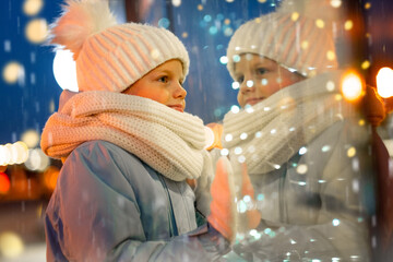 Portrait Boy looking and dreaming in Christmas window shopping on traditional Christmas market....