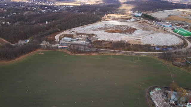 Aerial drone view of stack of different types of large mountain garbage pile, gulls feeding on food waste fly over It, waste disposal in dumping site, industrial factory in environmental pollution