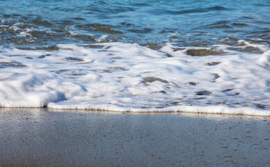 Fototapeta na wymiar abstract background, sea foam on a wet sandy beach, horizontal