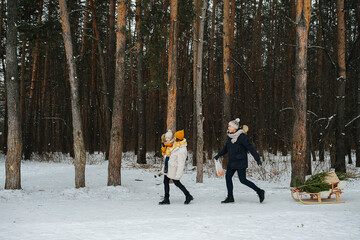 Side view of couple on a walk through the winter park with a child