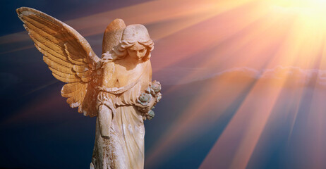 Antique statue of beautiful angel against the sky