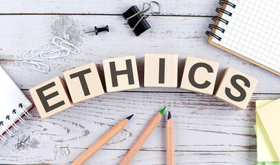 ETHICS text on wooden block with office tools on the wooden background