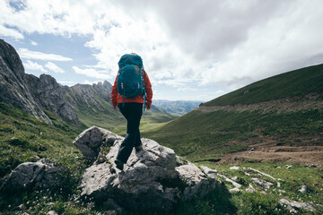 Woman hiker hiking on high altitude mountain top