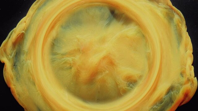 Ink water swirl. Circle frame opener. Fume vortex animation. Bright orange yellow smoke whirl flow motion on black abstract art background with glitter dust particles.