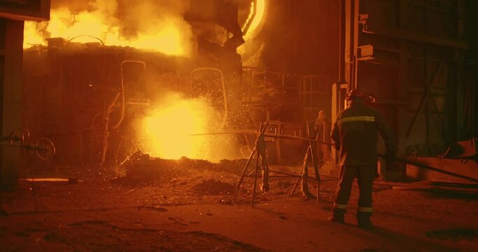 The worker of the steel plant measures the temperature in the furnace for melting metal. Metallurgical plant, blast furnace metal.