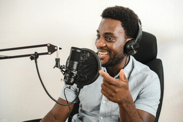 Delighted black man recording podcast and talking in mic