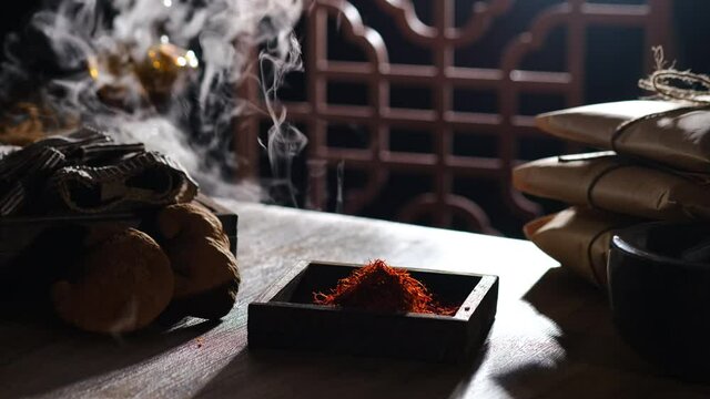 Lighting and smoke with saffron turmeric mushroom pack of medicine in a table , for chinese traditional medicine advertising , front view	
