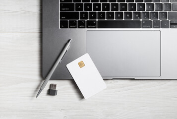 Online business concept. Blank bank card, pen, flash drive and laptop keyboard.