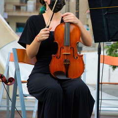 Closeup shot of a female musician with the violin in an orchestra