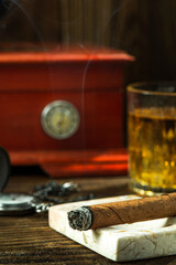 Smoking Cuban Cigar. Tobacco and Humidor on Wooden Table