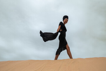 Smiling woman walking along sand dune