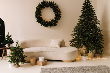Christmas Scandinavian minimalist interior of a living room with a sofa and a decorated wreath in a cozy house. Selective focus