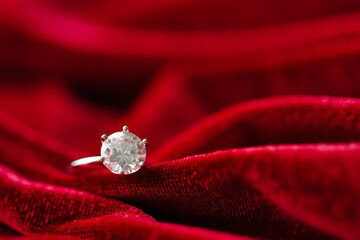 Diamond ring on red fabric background