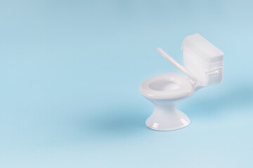 Miniature toilet on a blue background. space for text, isolated