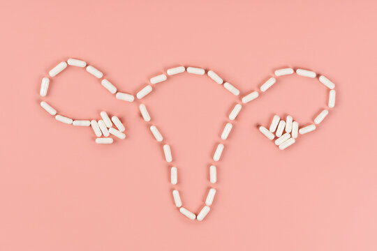 The uterus is laid out of tablets on a pink background. Space for text