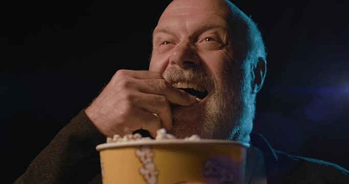 Senior man watching a comedy movie at the cinema