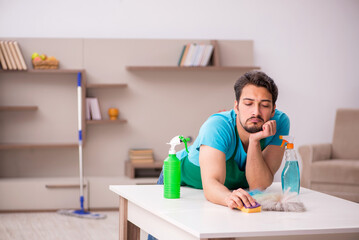 Young male contractor cleaning the house