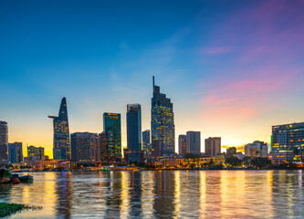 Obraz na płótnie Canvas Riverside urban area at sunset sky after a period of social distancing because of the pandemic has revived in Ho Chi Minh City, Vietnam