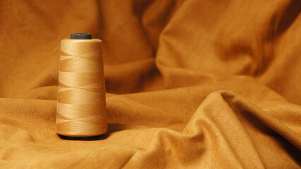 A spool of red thread on a red background