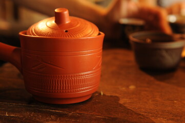 chinese red clay teapot with ornament on table
