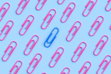 Pink and blue paperclip stand out from the crowd. One different concept. Male and female gender symbol. Feminism and unequal sexes social issue.