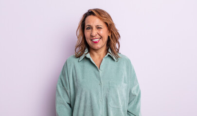 middle age woman looking happy and friendly, smiling and winking an eye at you with a positive...
