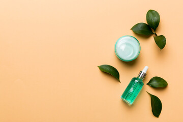 Organic cosmetic products with green leaves on color background. Copy space, flat lay