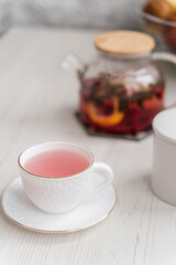cup and teapot with rose tea on the table