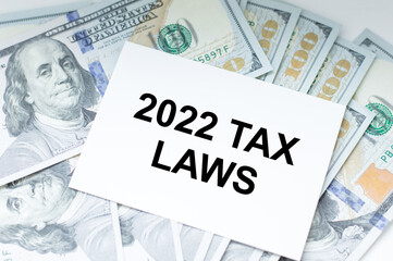 2022 TAX LAWS text on a business card that lies among the money on the table, business and finance