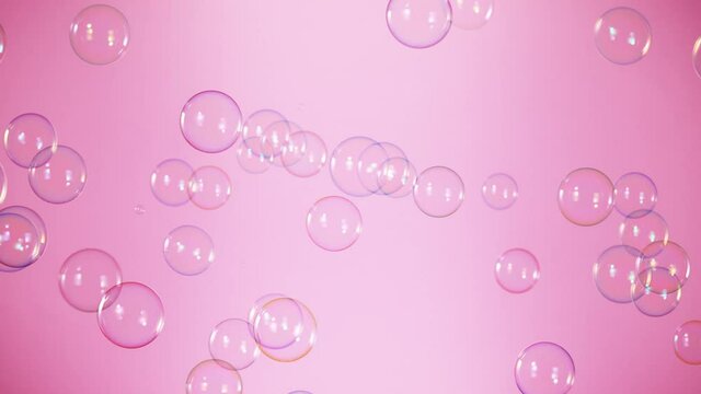Super Slow Motion Shot of Flying Colorful Soap Bubbles on Pink Background at 1000 fps.