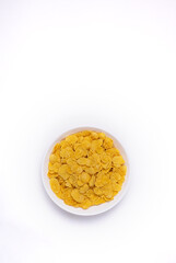 Cornflakes on bowl isolated on white background top view
