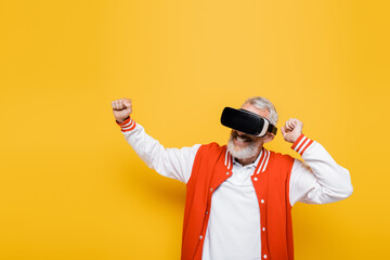 smiling middle aged man in bomber jacket and vr headset gesturing on yellow