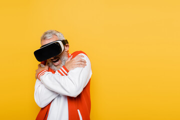 scared middle aged man in bomber jacket and vr headset isolated on yellow