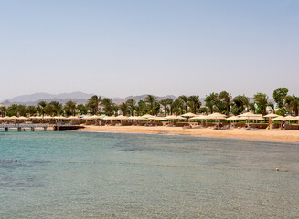 Hurghada, Egypt - September 22, 2021: View of the Red Sea coast. People are relaxing and swimming on the sandy beach. Copy space.