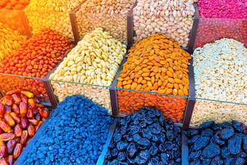 Counter with dried fruits and nuts in the oriental bazaar. Variety of natural organic sweets and...