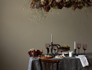 Fancy Table setting with candles and flowers and fruits. Copy space