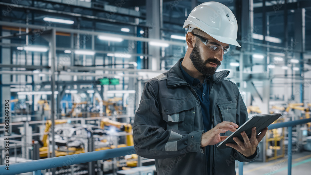 Leinwandbilder car factory engineer in work uniform using tablet computer. automotive industrial manufacturing faci
