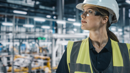 Portrait of Female Automotive Industry Engineer Wearing Safety Glasses and High Visibility Vest at...
