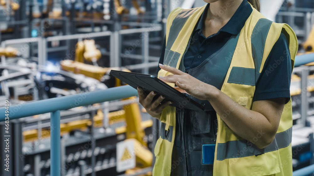 Aufkleber close up of female car factory engineer in high visibility vest using tablet computer. automotive in