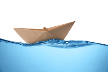 Handmade kraft paper boat floating on clear water against white background