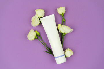 Hand cream, moisturizer, toothpaste, lotion jar plastic tube with white flowers lilac background. Brand spa packaging mock up. Freshness and hygiene concept.