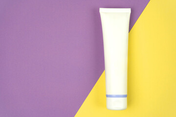 Hand cream, moisturizer, toothpaste, lotion jar plastic tube on lilac and yellow background. Brand spa packaging mock up. Copy space