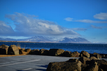 Akranes, iceland snow-capped mountain peaks and blue waters of the bay