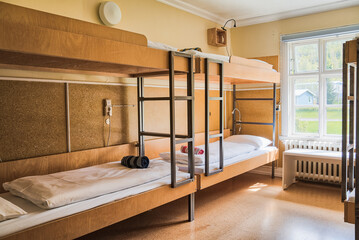 Cosy and quiet room with bunk beds and walls covered with warm colours and ecological environment and recycled materials.Family room. Shared hostel room. Nordic atmosphere and decoration. - obrazy, fototapety, plakaty