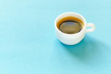 White coffee cup on blue background with free space for text