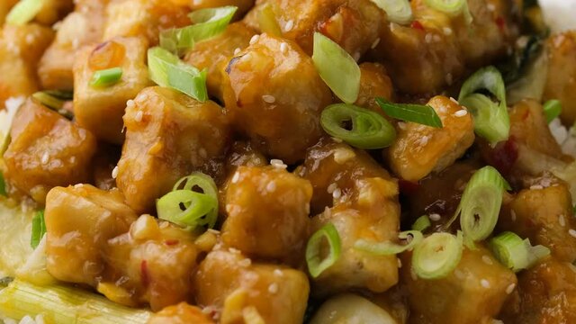 General Tso Tofu with rice, green onion and pak choi. Asian Vegan Food. Rotating video