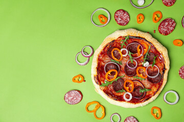 Concept of tasty food with Salami pizza on green background