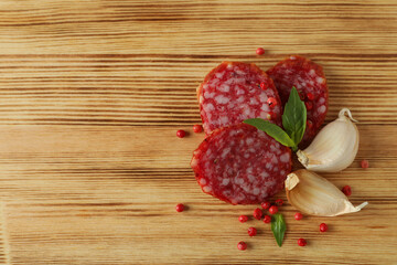 Сoncept of tasty food with salami sausage on wooden background